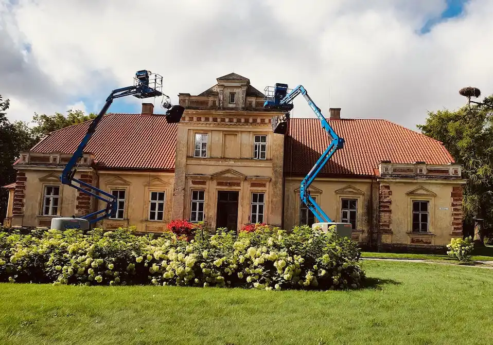 Atgimęs Jakiškių dvaras vasarą, autentiškas pastatas su gėlėmis ir mėlynu dangumi